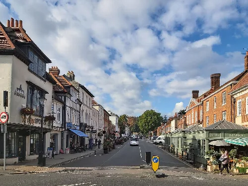 View of Castle Street in Farnham with historic buildings and Fox's Tower at the top.