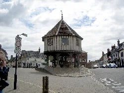 Edificio de madera redondo en una plataforma de piedra en la plaza del pueblo.