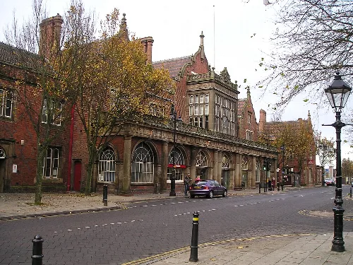 Street view with historic buildings, trees, and street lamps in Stoke-upon-Trent.