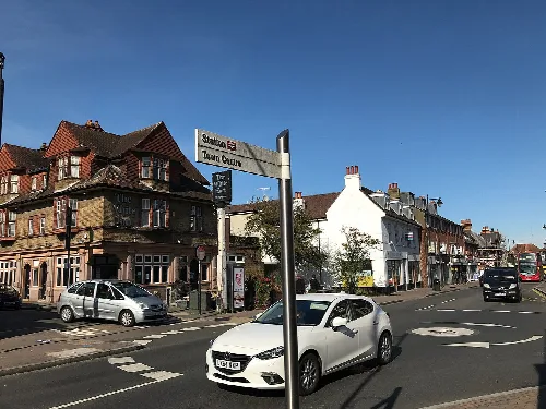 Pub White Hart en la calle principal de Orpington con coches y señales de tráfico.