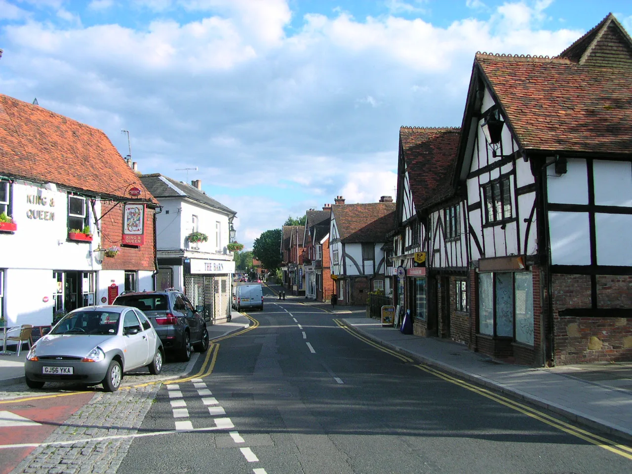 A street in Edenbridge with timber-framed buildings and parked cars.