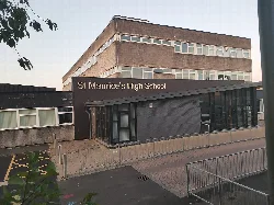 Modernes Schulgebäude mit einem Schild, das St Maurice's High School liest.