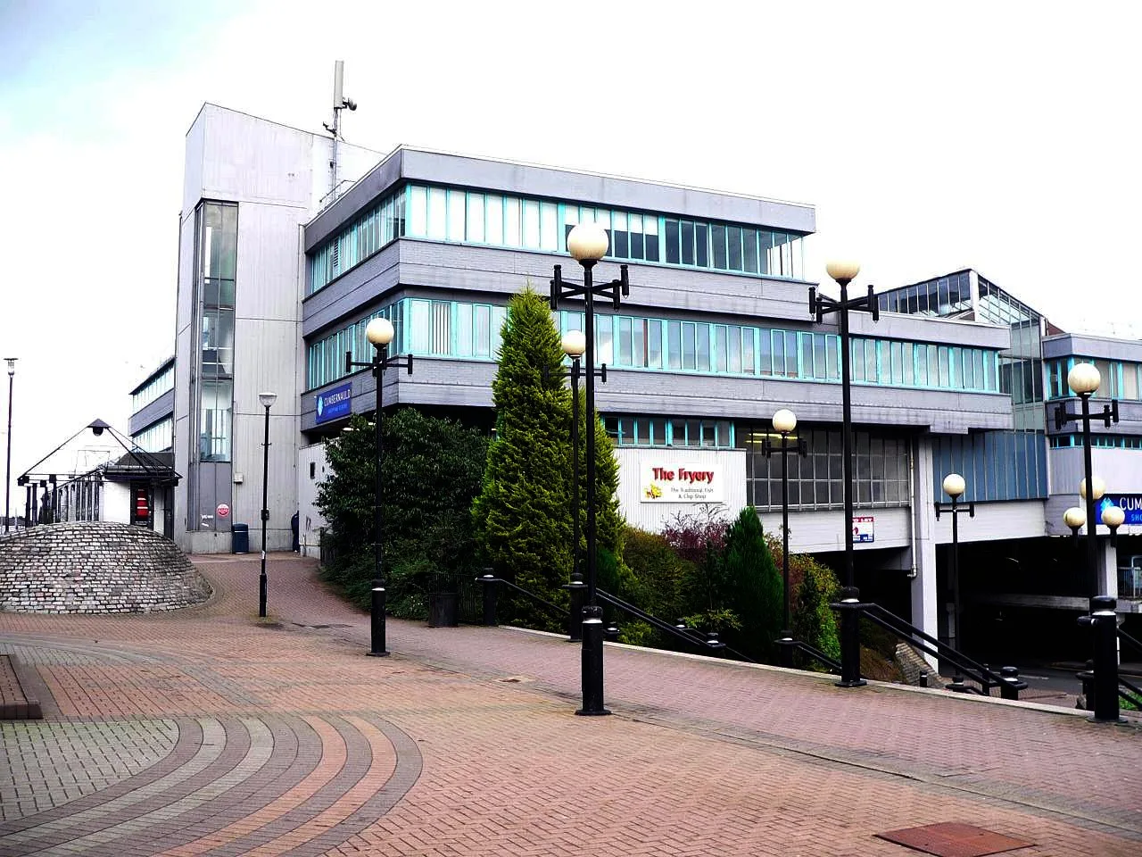 Modernes graues Einkaufszentrum mit Straßenlaternen in Cumbernauld.