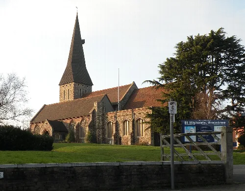 Iglesia de piedra con una aguja alta y puntiaguda y ventanas arqueadas en Braintree.