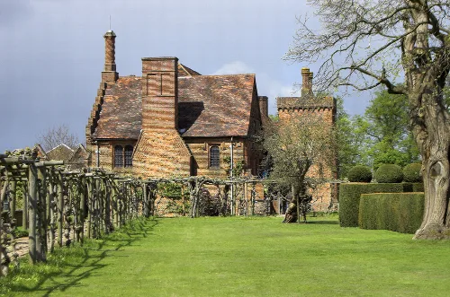 Fachada sur del Antiguo Palacio en Hatfield House con jardín y árboles.