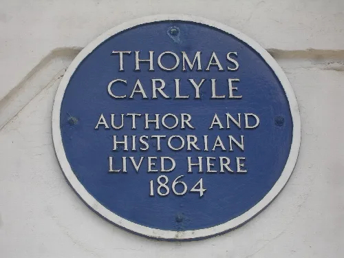 Blue circular plaque with white text about Thomas Carlyle.