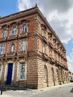 Un gran edificio de ayuntamiento de ladrillo y piedra con estatuas y ventanas arqueadas en Louth.