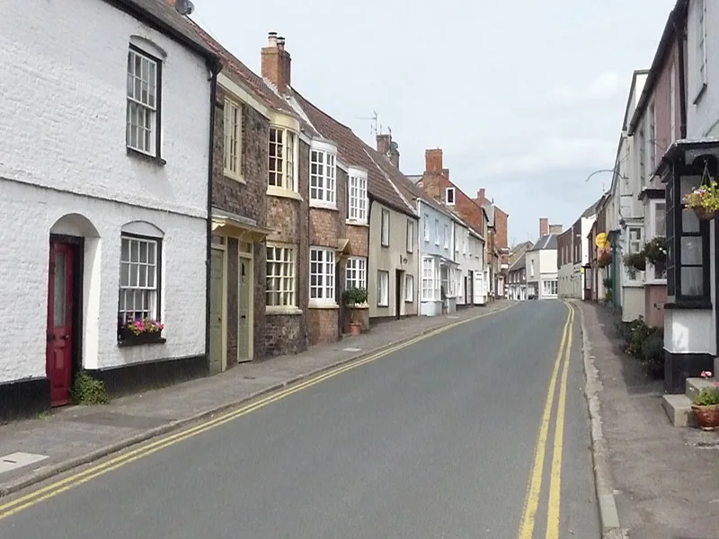 A street with terraced houses and flower boxes on the windows.