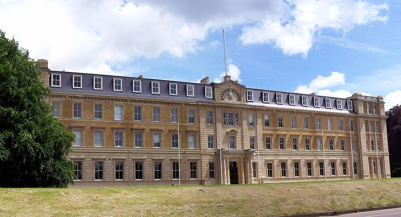 Un gran edificio histórico con fachada simétrica y muchas ventanas en Camberley.