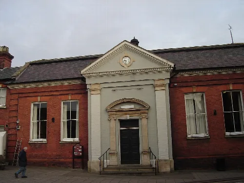 Red brick town hall with white pediment and black door in Aylsham.