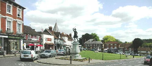 Statue of General Wolfe in Westerham town square with shops and cars.