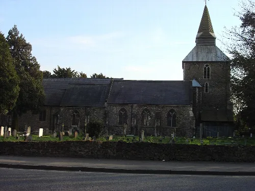 Stone church with a tall steeple and arched windows.
