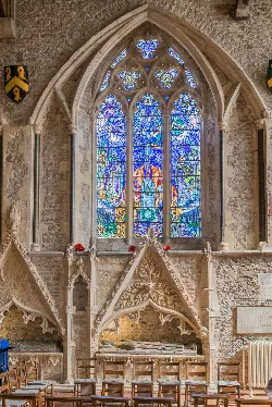 Colorful stained glass window in a stone church.